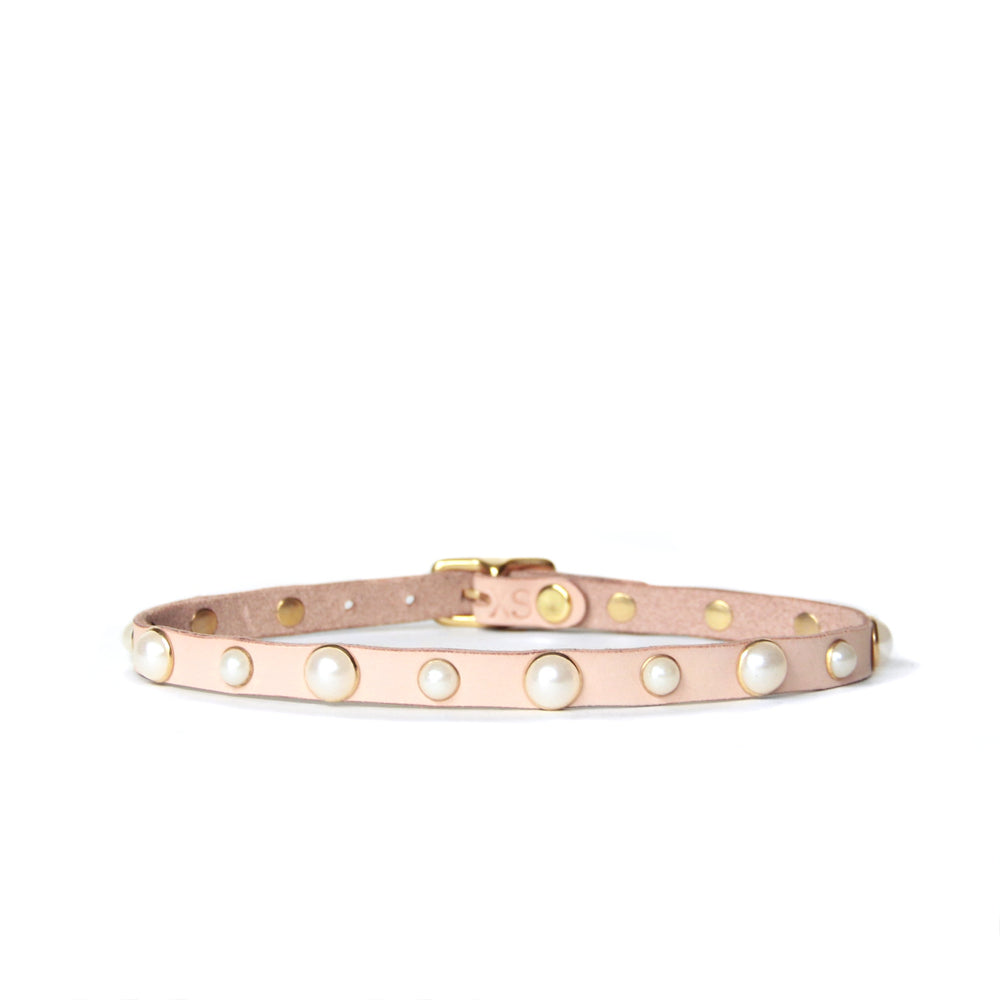 Thin leather choker created from a peachy beige toned natural leather studded with pearls trimmed in gold.